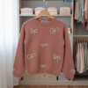 Pull rose poudré à nœuds perlés – Élégance féminine